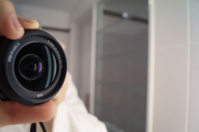 Cropped image of man photographing in bathroom