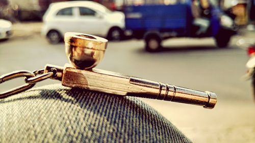 Close-up of smoking pipe against road