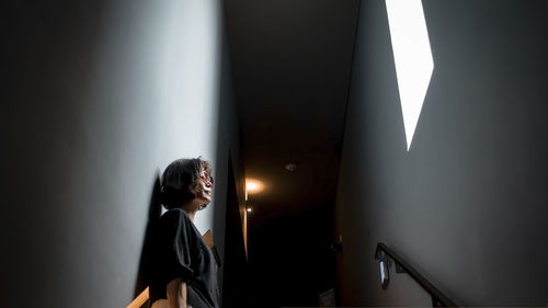 Rear view of woman standing against wall