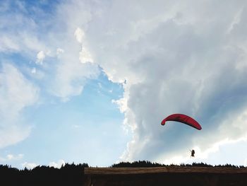 Low angle view of person paragliding against sky