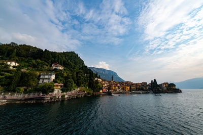 Scenic view of sea by buildings against sky