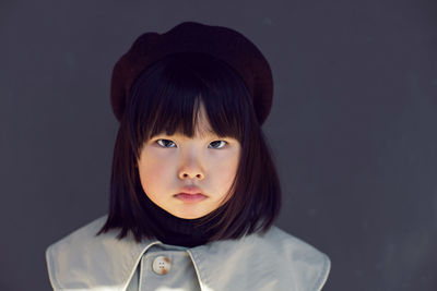 Korean girl in a gray coat and cap and stands the street in spring.