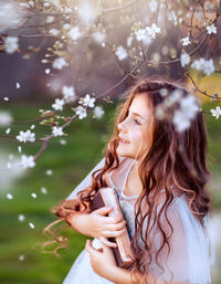 Midsection of woman standing by tree