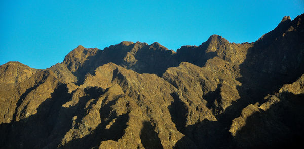 Scenic view of mountains against clear blue sky