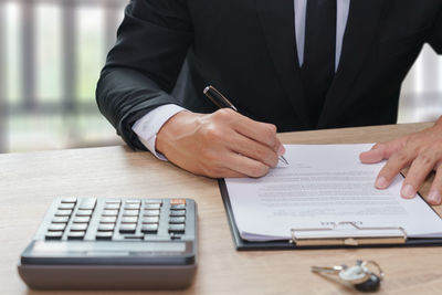 Midsection of man with umbrella on table