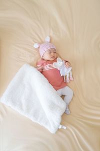 High angle view of cute baby lying on bed