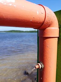 Close-up of water drop on beach against sky