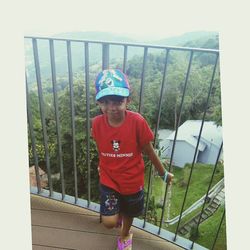 Portrait of boy standing by railing