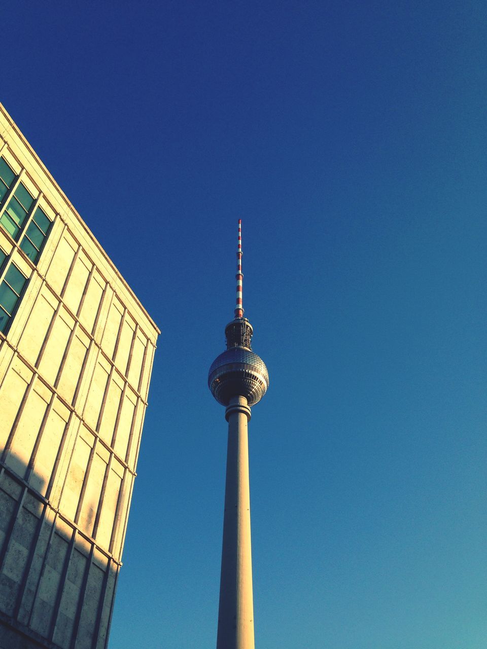 architecture, built structure, building exterior, tower, communications tower, tall - high, clear sky, spire, low angle view, city, fernsehturm, capital cities, famous place, international landmark, travel destinations, communication, television tower, blue, tourism, culture