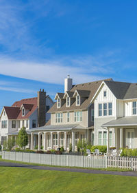 Houses by building against blue sky