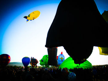 People in hot air balloons against sky