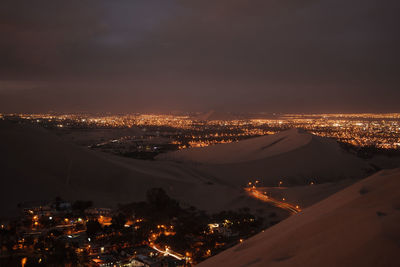 High angle view of city lit up at night