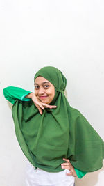 Portrait of smiling young woman against white background