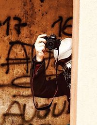 Man photographing against wall