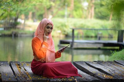 Portrait of woman sitting on bridge