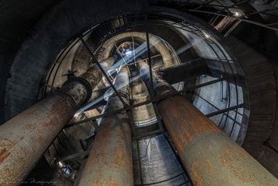 Low angle view of old rusty pipes in building