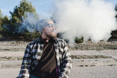 Young man smoking with a electronic cigarette