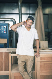 Portrait of confident carpenter standing in workshop