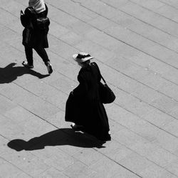 High angle view of women walking on footpath during sunny day