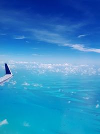 Airplane flying over sea against blue sky