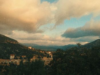 Scenic view of townscape and mountains against sky