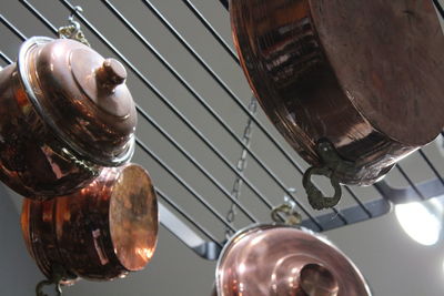 Low angle view of utensils hanging from rack in kitchen