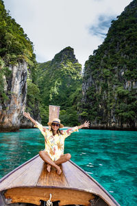 Portrait of man sitting on wood against sea