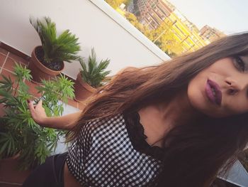 Portrait of smiling young woman against plants