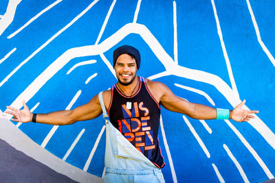 Brazilian male model agains mural graffiti wall. colorful graffiti wall.