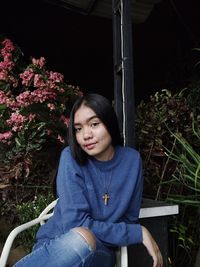 Portrait of young woman sitting on field