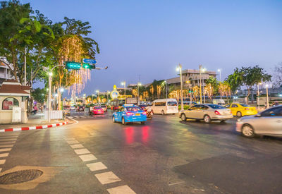 Cars on road in city against sky