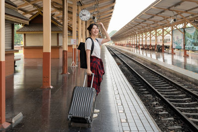 Rear view of woman walking on railroad station