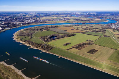 High angle view of river amidst field against sky
