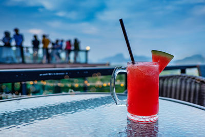 Close-up of red wine glass against swimming pool