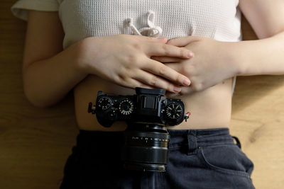 Midsection of man holding camera