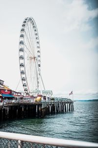 Ferris wheel in sea against sky