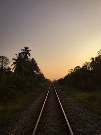 Railroad tracks against sky during sunset