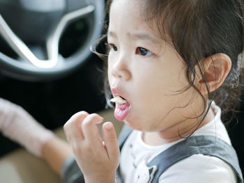 Close-up of girl eating food in car