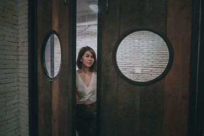 Portrait of woman standing by door