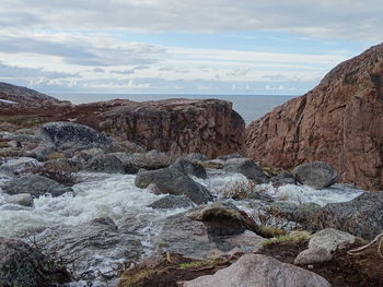 Scenic view of rocks in sea against sky