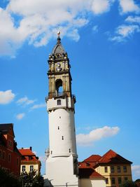 Low angle view of clock tower amidst buildings against sky