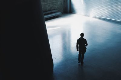 Rear view of man walking on floor