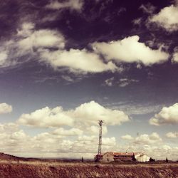 Scenic view of agricultural field against cloudy sky