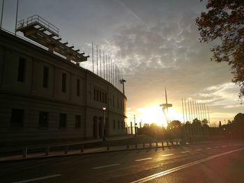 Road by city against sky during sunset