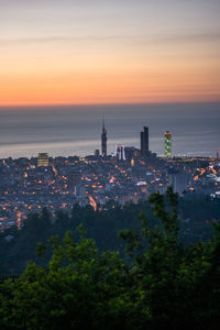 High angle view of illuminated buildings against sky at sunset
