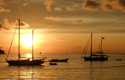 Silhouette of sailboat in sea against sky during sunset