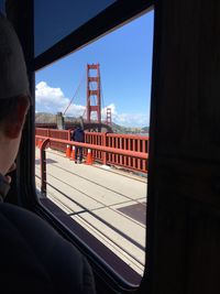 Man seen through bridge against sky