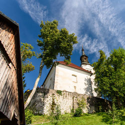 Low angle view of trees and building against sky