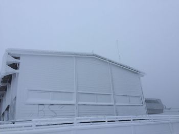 Low angle view of building against clear sky during winter