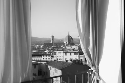 Florence cathedral in city against clear sky seen through window